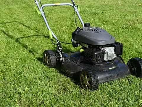 Lawn mower on freshly cut green grass